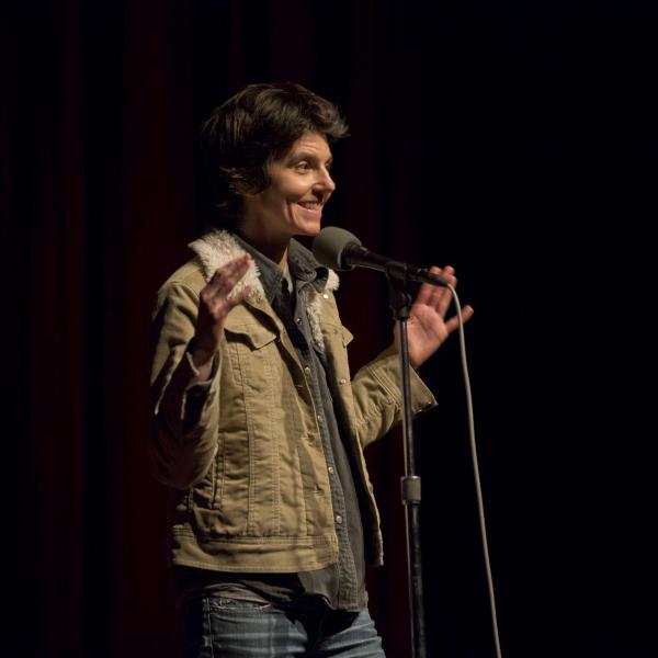 Woman on stage in front of a mic. 