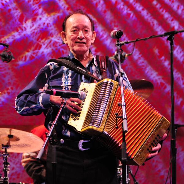 Man on stage playing accordion. 