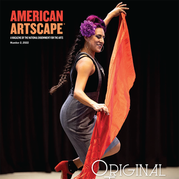 Vanessa Sanchez, who is a Latina woman, holds a large piece of orange fabric while she dances
