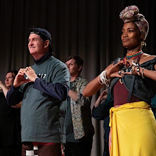 Man and woman on stage with hands in the heart shape