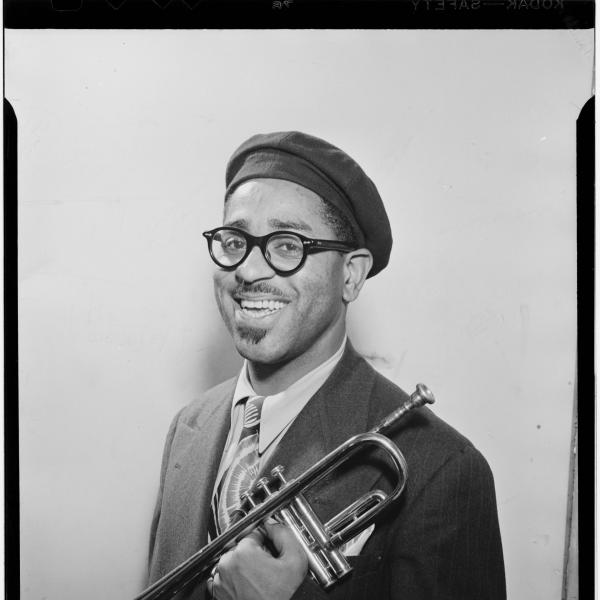 Portrait of man in beret holding a trumpet.