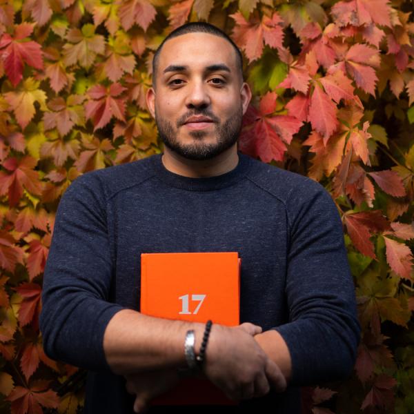 A man clutching a book in his arms.