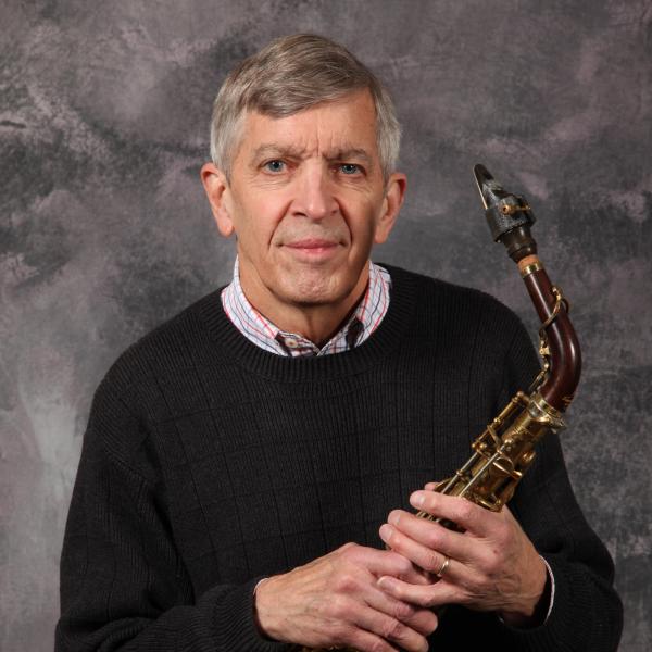 Portrait of man holding saxophone. 