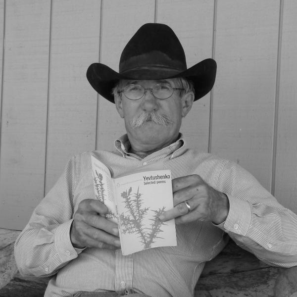Man in cowboy hat reading a book. 