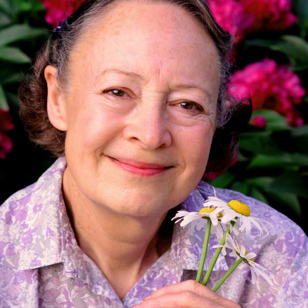 Portrait of woman holding flowers.