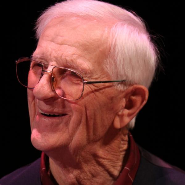 Man smiling, holding a basket.