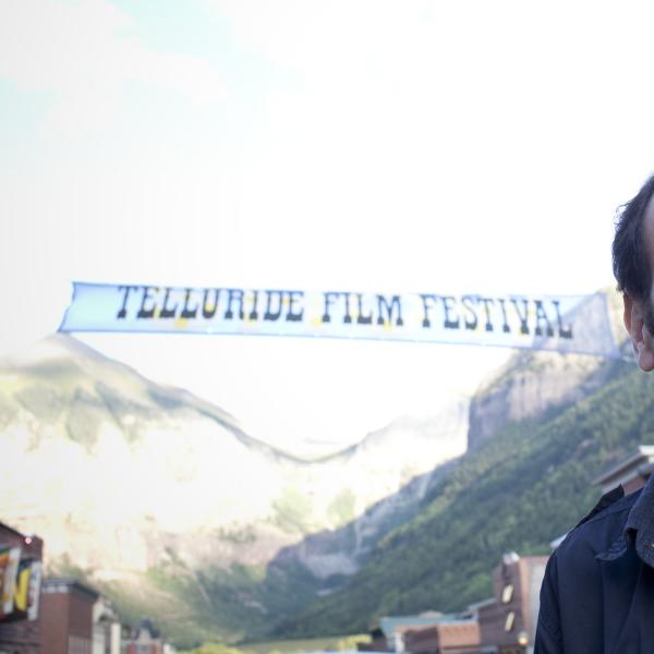 Man standing outdoors in front of a banner