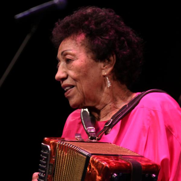 Woman on stage playing an accordion.