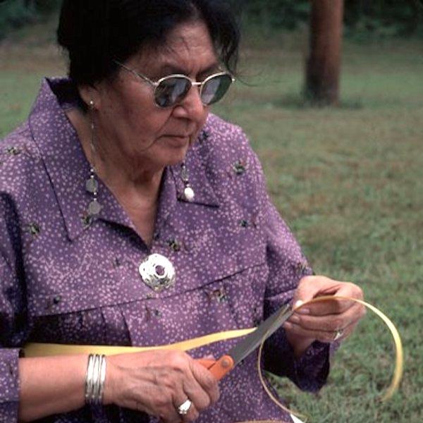 A woman weaving a basket.