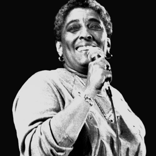 Woman with mic singing. 