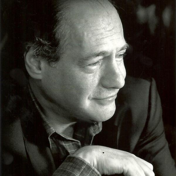Portrait of white man, balding, wearing a suitcoat and looking to his left. 