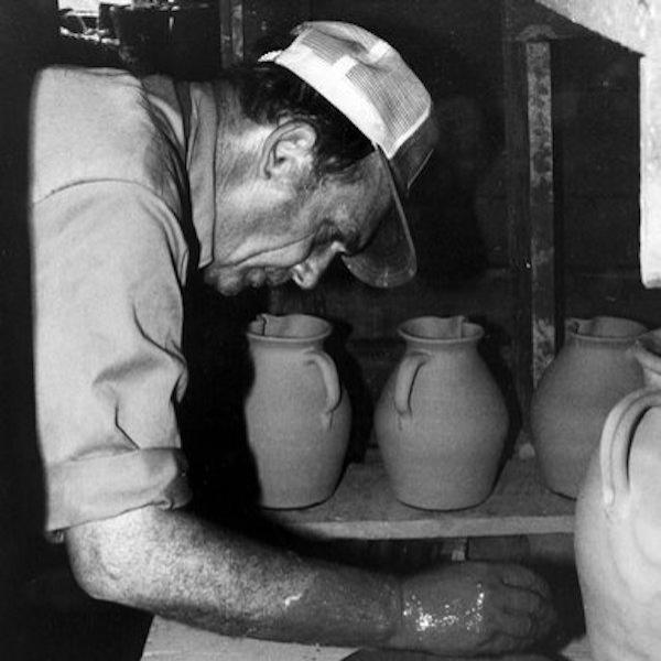 A man shapping a clay pot.