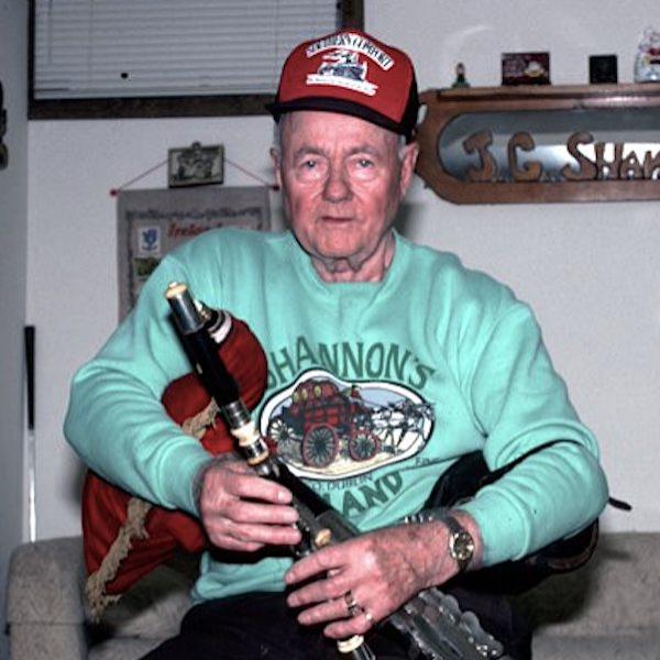 A man holding a bag pipe.