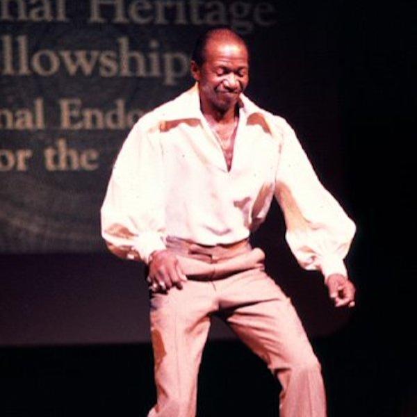 A man tap dancing on a stage.