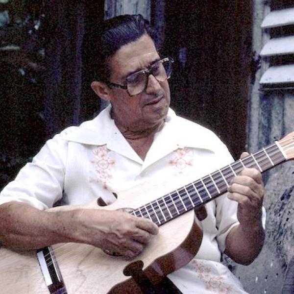 A man playing a Puertorican cuatro.