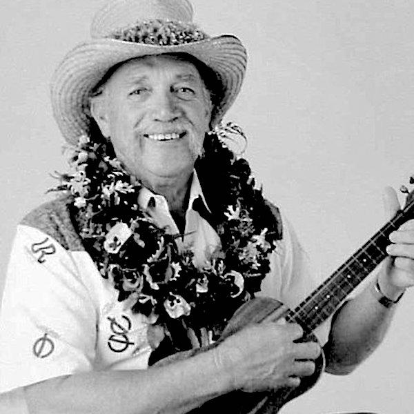 A man in a tall hat a plaing a ukelele.