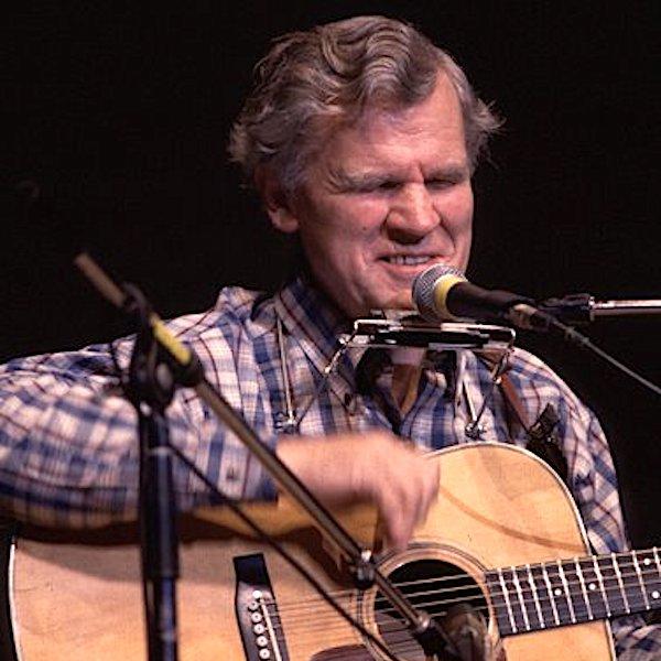 A man playing a guitar on stage.