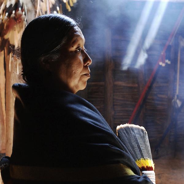 A woman shrouded in a native shawl seen in profile.