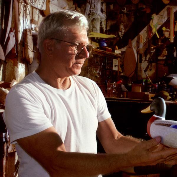 A man holding a model diuck in his hands.