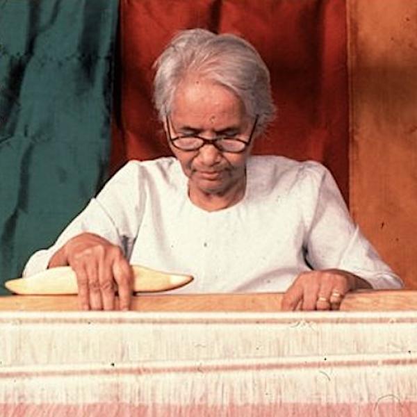 A woman sitted at a loom.