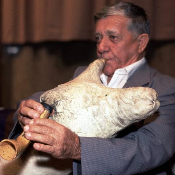 A man playing a skin bagpipe.