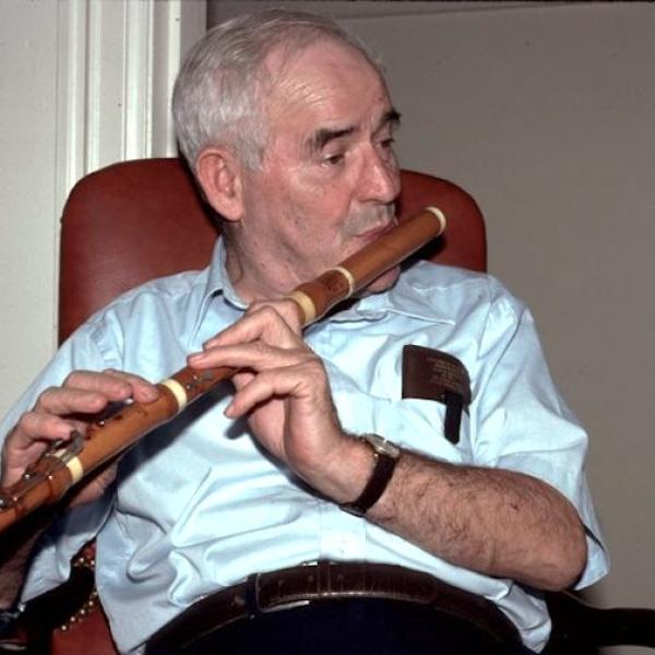 A man playing a wooden flute.