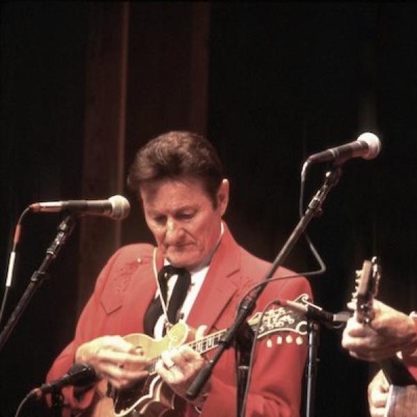 Two men on stage playing their instruments.