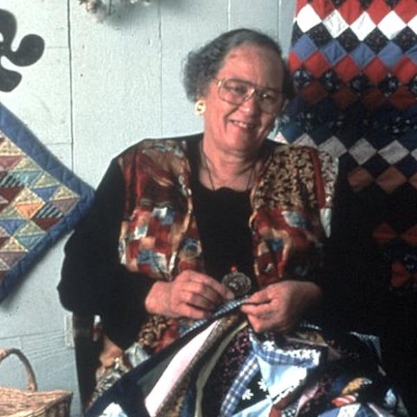 A woman sowing a quilt.