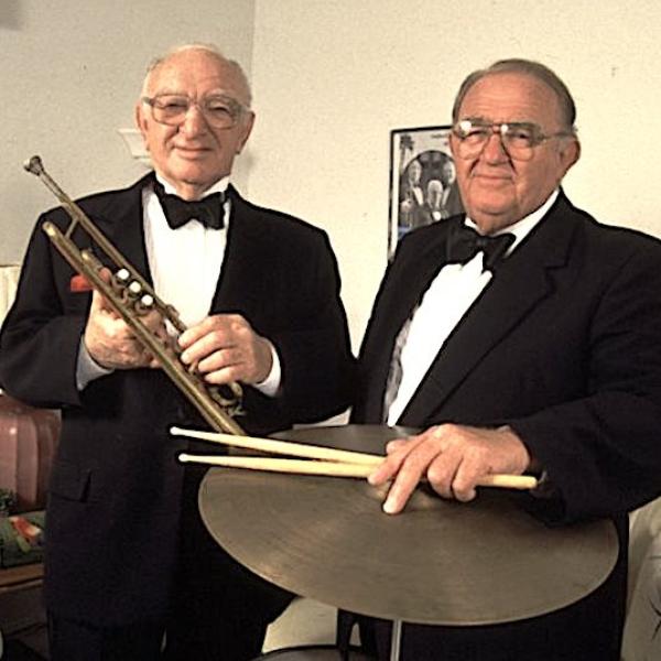 Two men dfressed in suits.