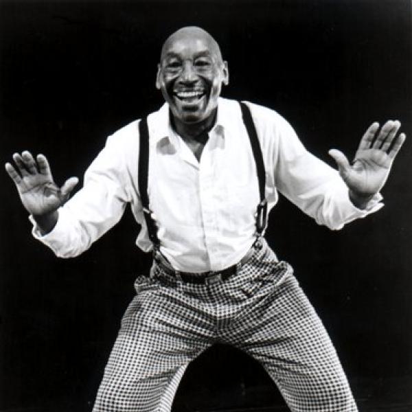 A man holding up both hands faces the camera.