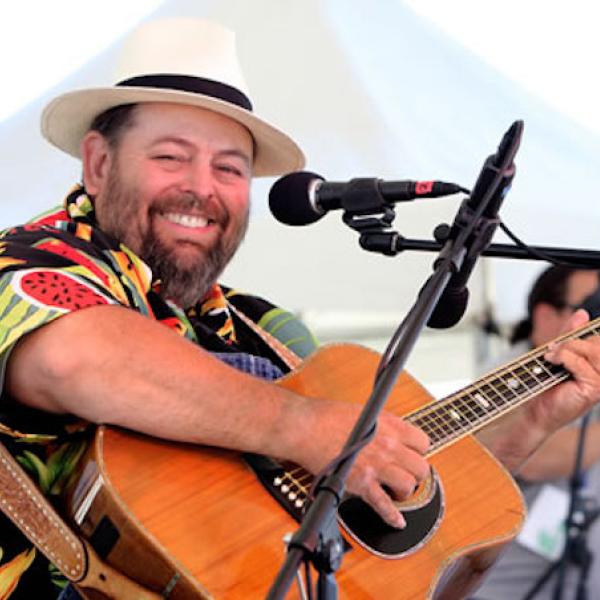 A man playing the guitar onstage.