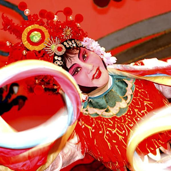A woman in an elaborate costume strikes a dance pose.