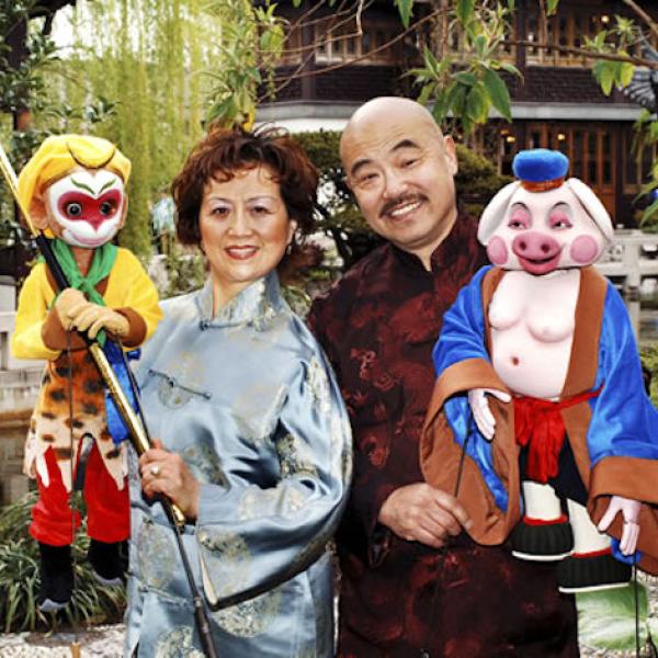 A man and a woman holding puppets.