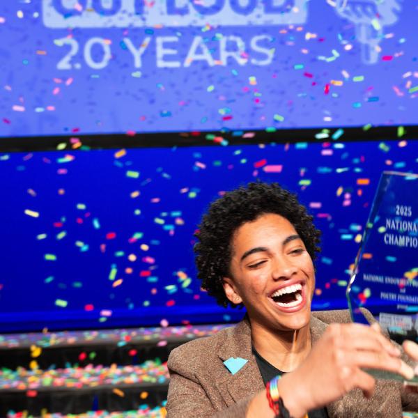 Isavel Mendoza smiling and holding his trophy while confetti falls around him