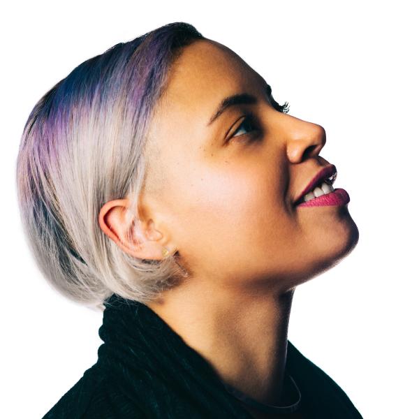 a light skinned woman with a short bob with streaks of purple