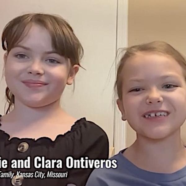 Two young female children up close speaking to the camera