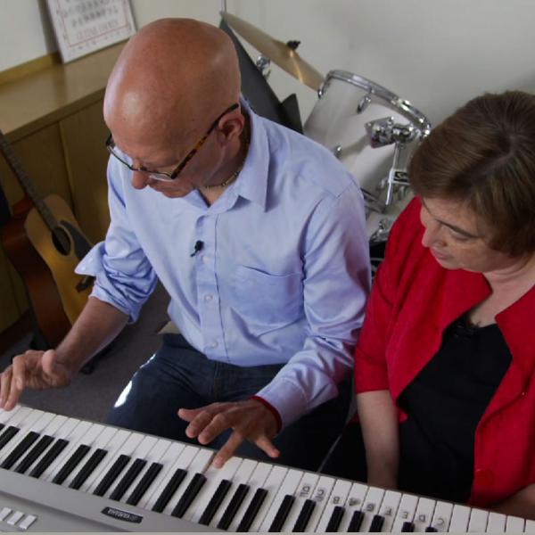 A music therapist  works with a patient recovering from a stroke