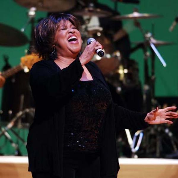 Woman singing on stage.