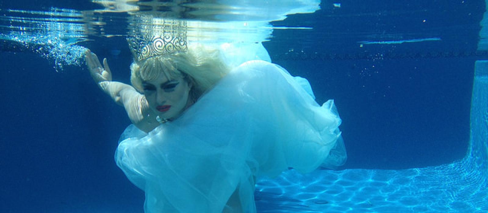 Drag queen in wedding dress underwater