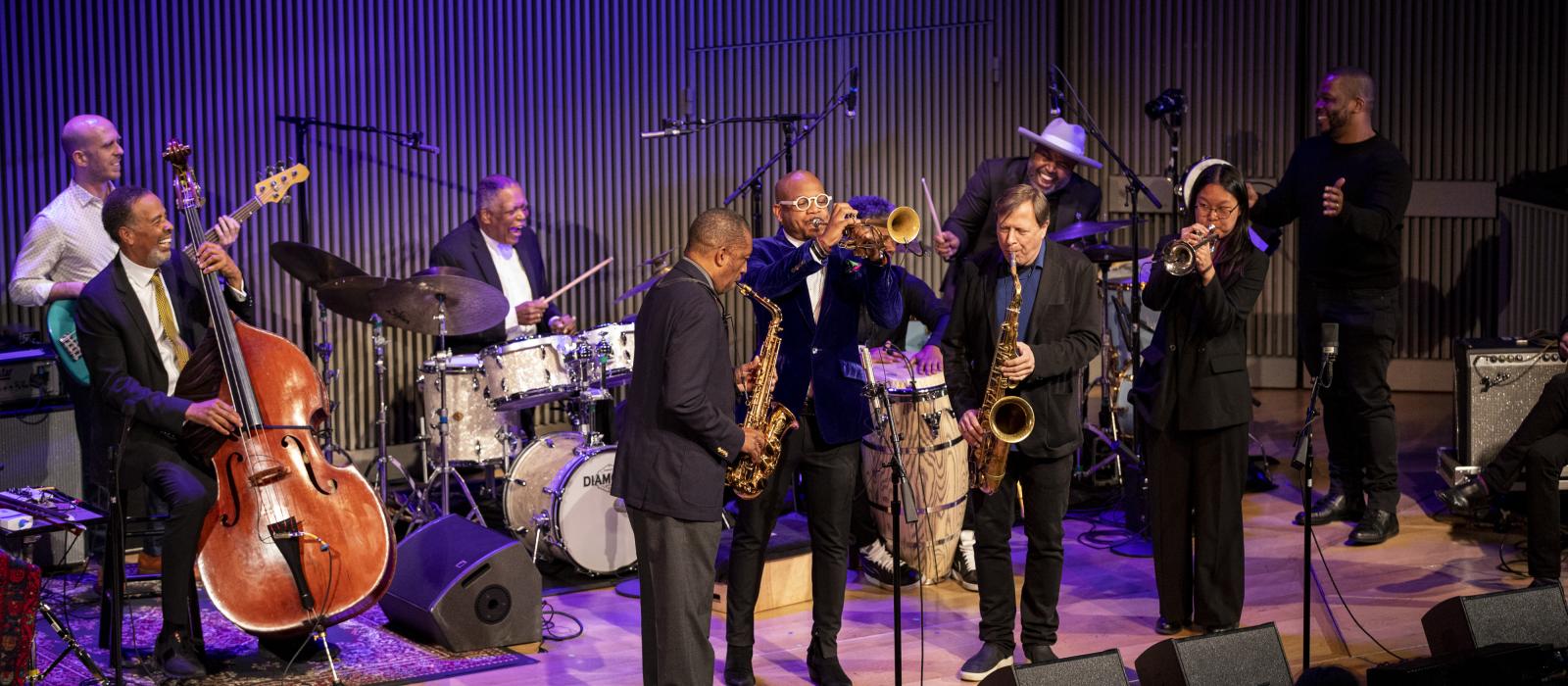 Jazz musicians on stage playing various instruments.