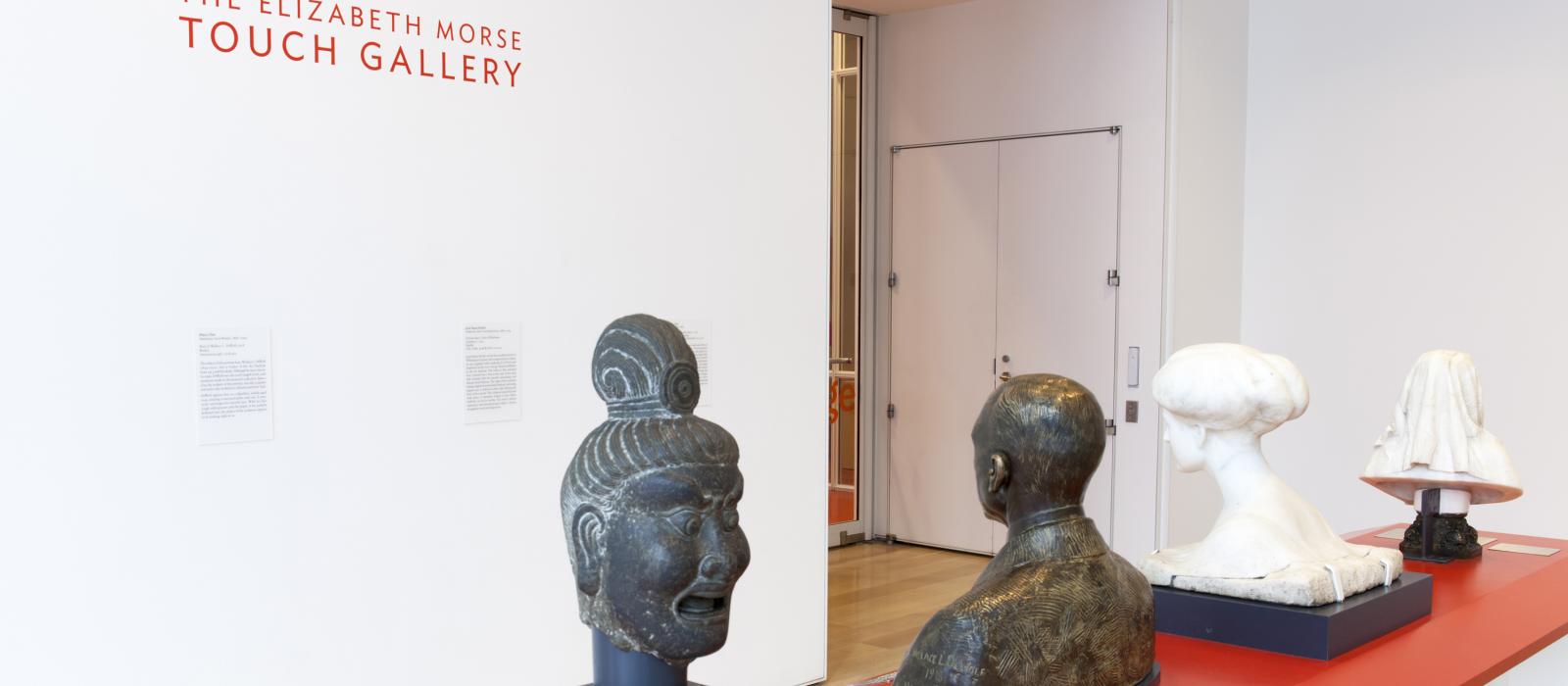 Four sculptures in a gallery set up for people to touch.