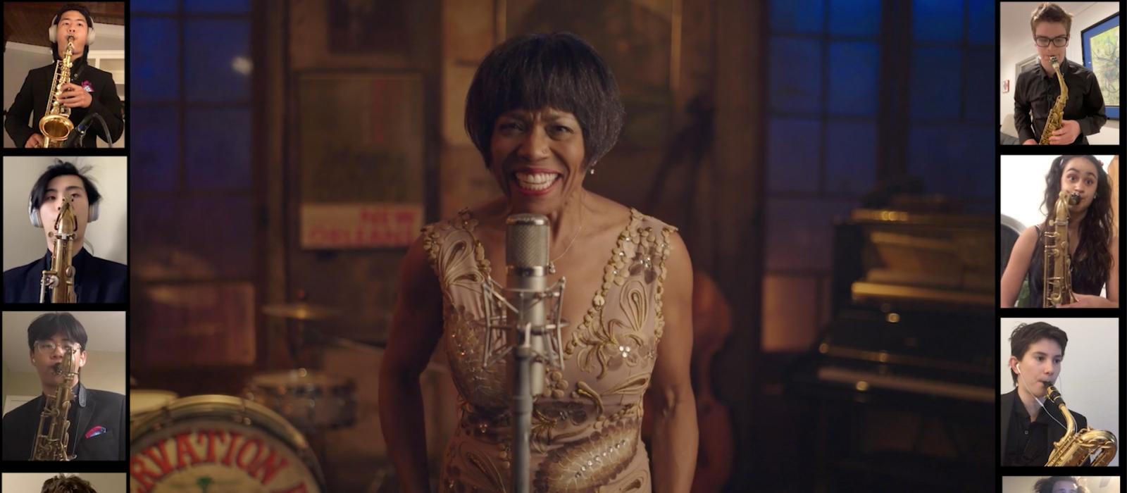 Woman in middle section of video singing with band members in small squares on each side of her.