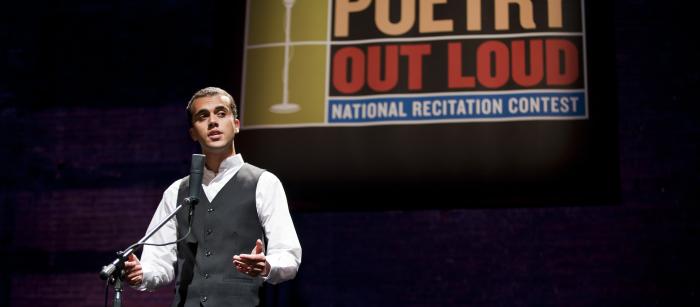 Teenage boy on stage reciting poetry.