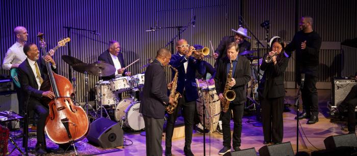 Jazz musicians on stage playing various instruments.