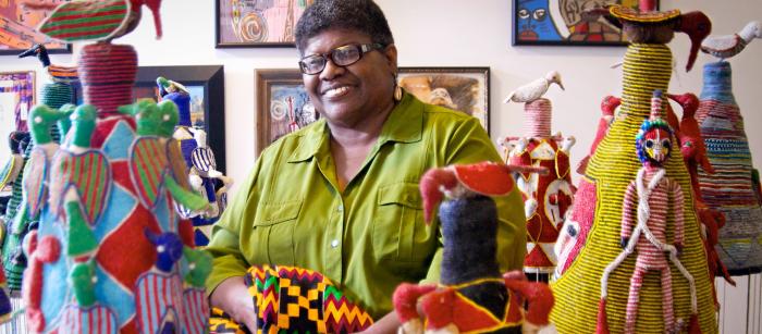 African-American woman surrounded by quilts.