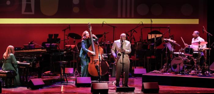 Musicians perform on a dramatically lit stage.