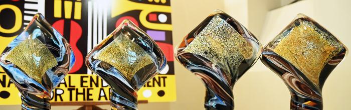 Group of four awards on table. 