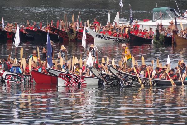 A group of canoe families conclude their journey, preparing to land on the shore of North Point in the Port of Olympia, Washington. Photo courtesy of ThurstonTalk.com