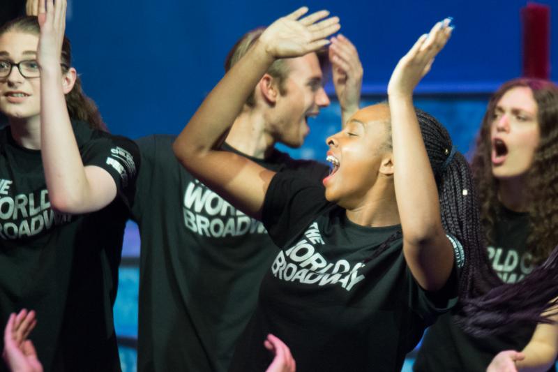 Children in black tee-shirts dancing around. 