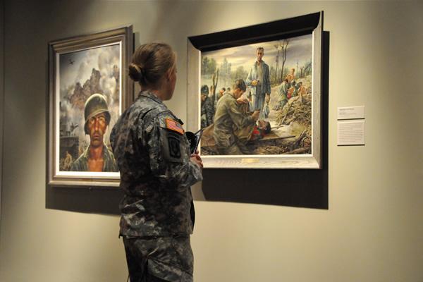 Woman in military uniform looking at art in museum. 